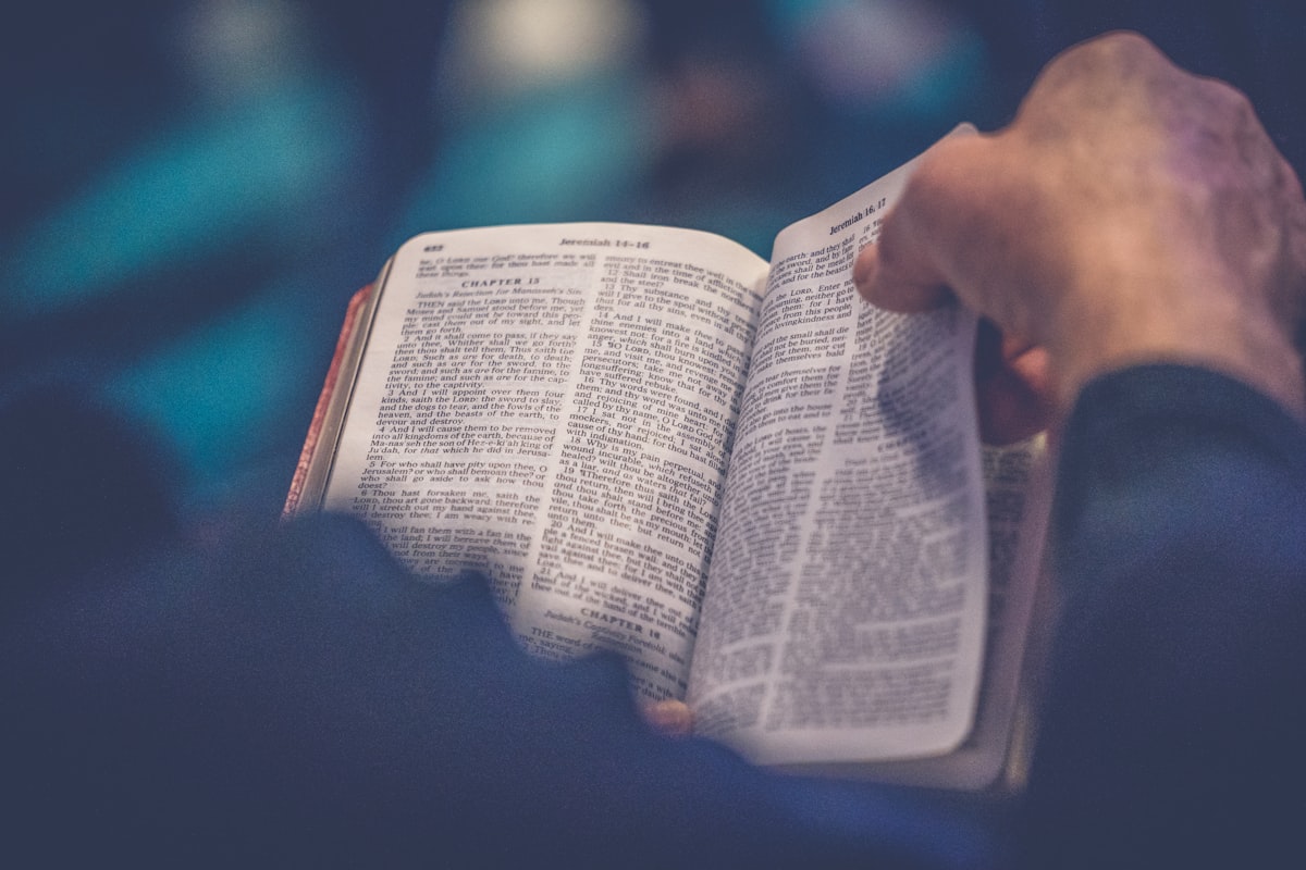 Hands holding an open Bible
